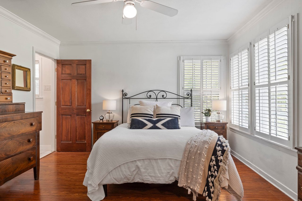 Bedroom with a mahogany dresser and plantation shutters at this Westover Rd property.