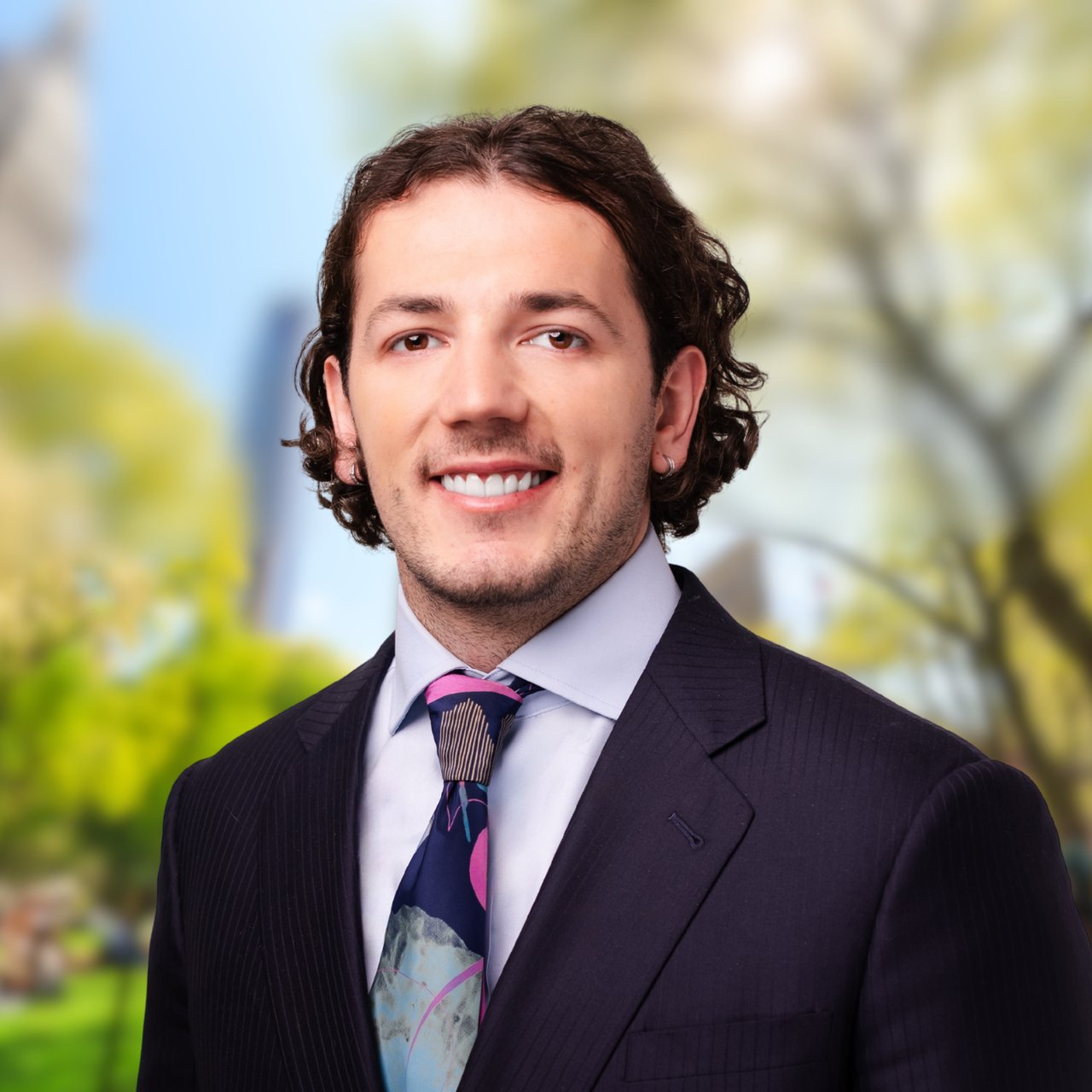 Vasil Vasilev in a dark pinstripe suit and colorful tie
