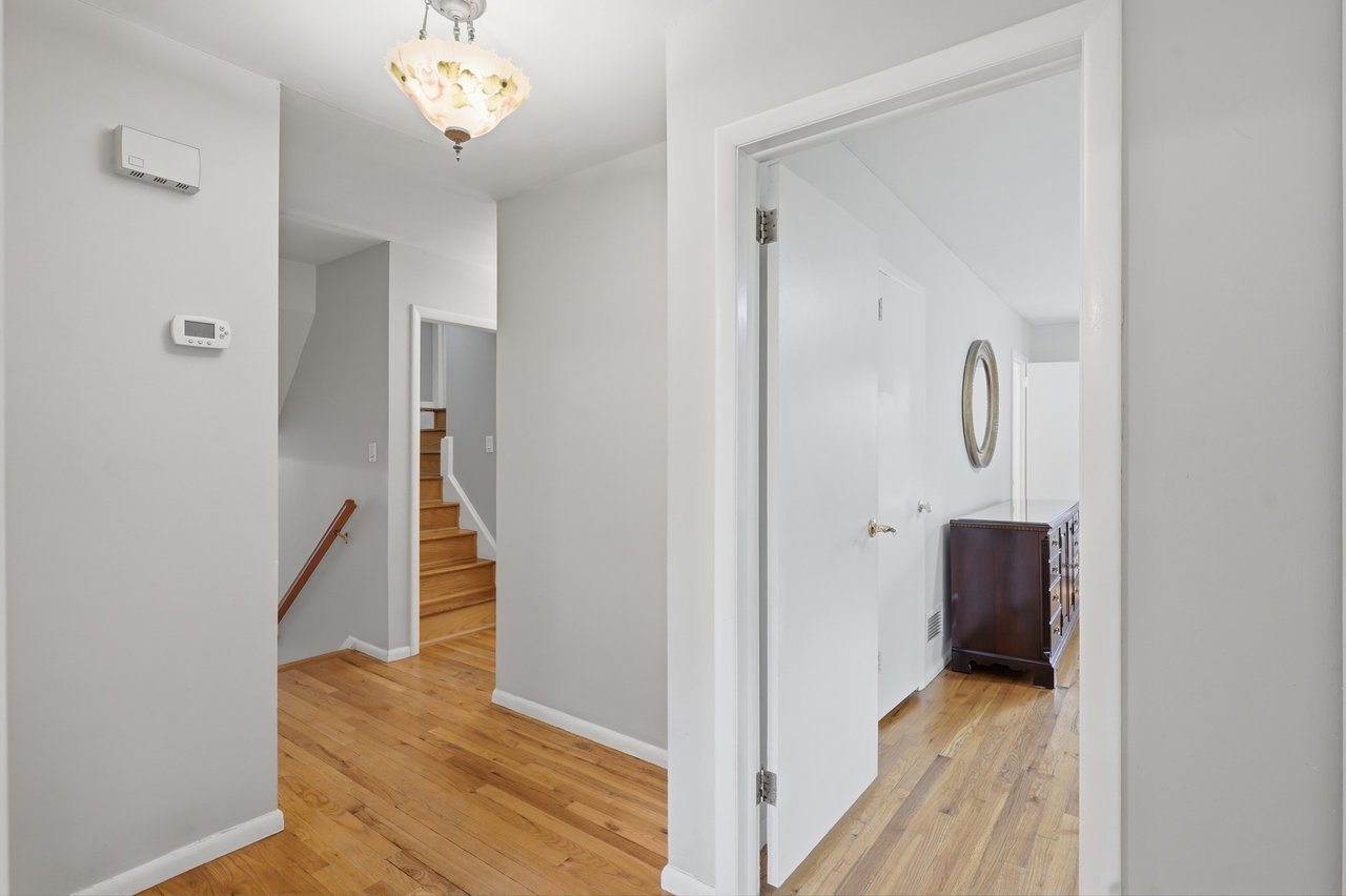 Hallway view of staircase to upper-bedroom and primary bedroom