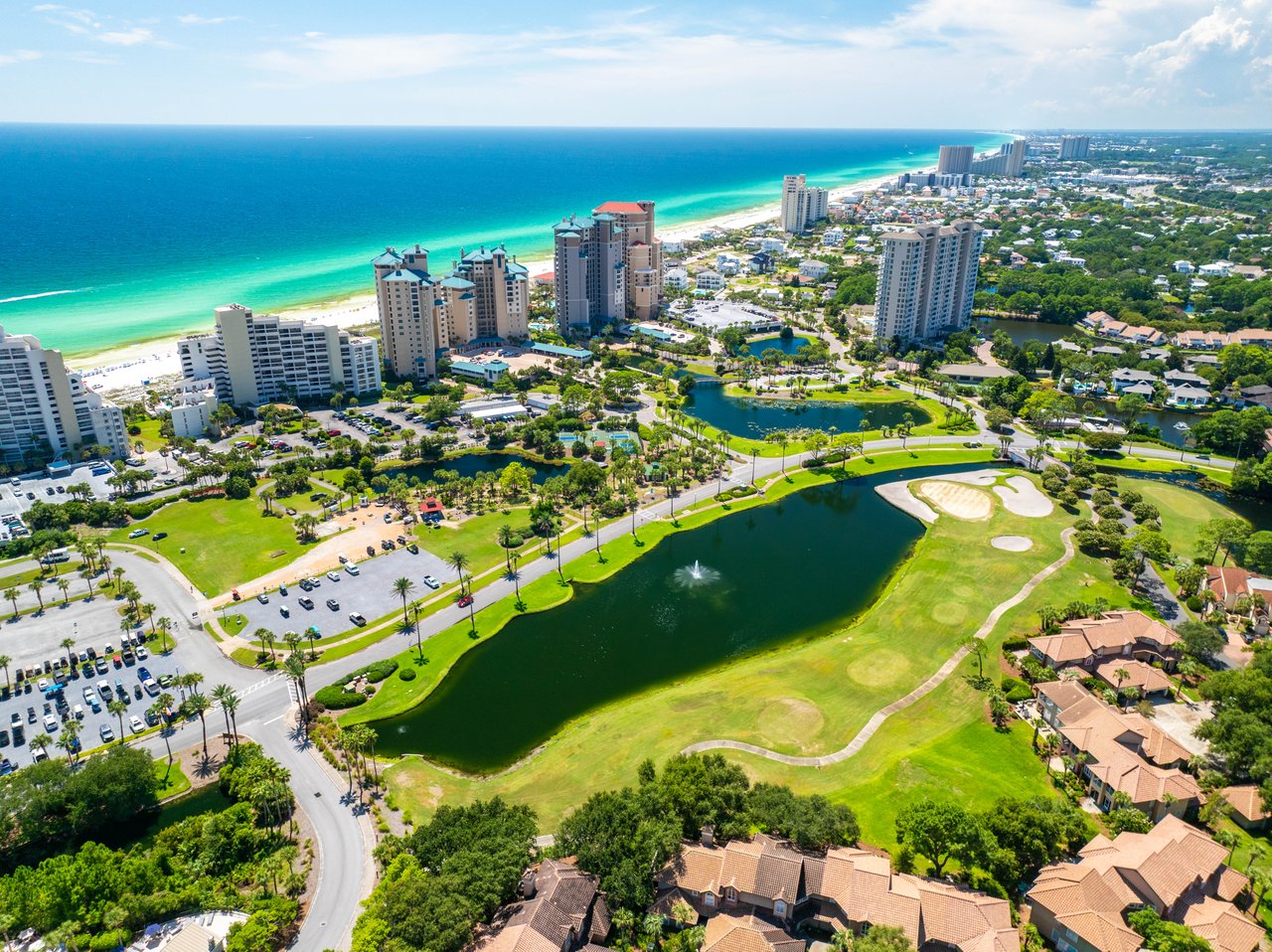 Aerial of Sandestin Golf & Beach Resort showing emerald Gulf water, beachfront towers and a palm-lined golf course in Miramar Beach, Florida