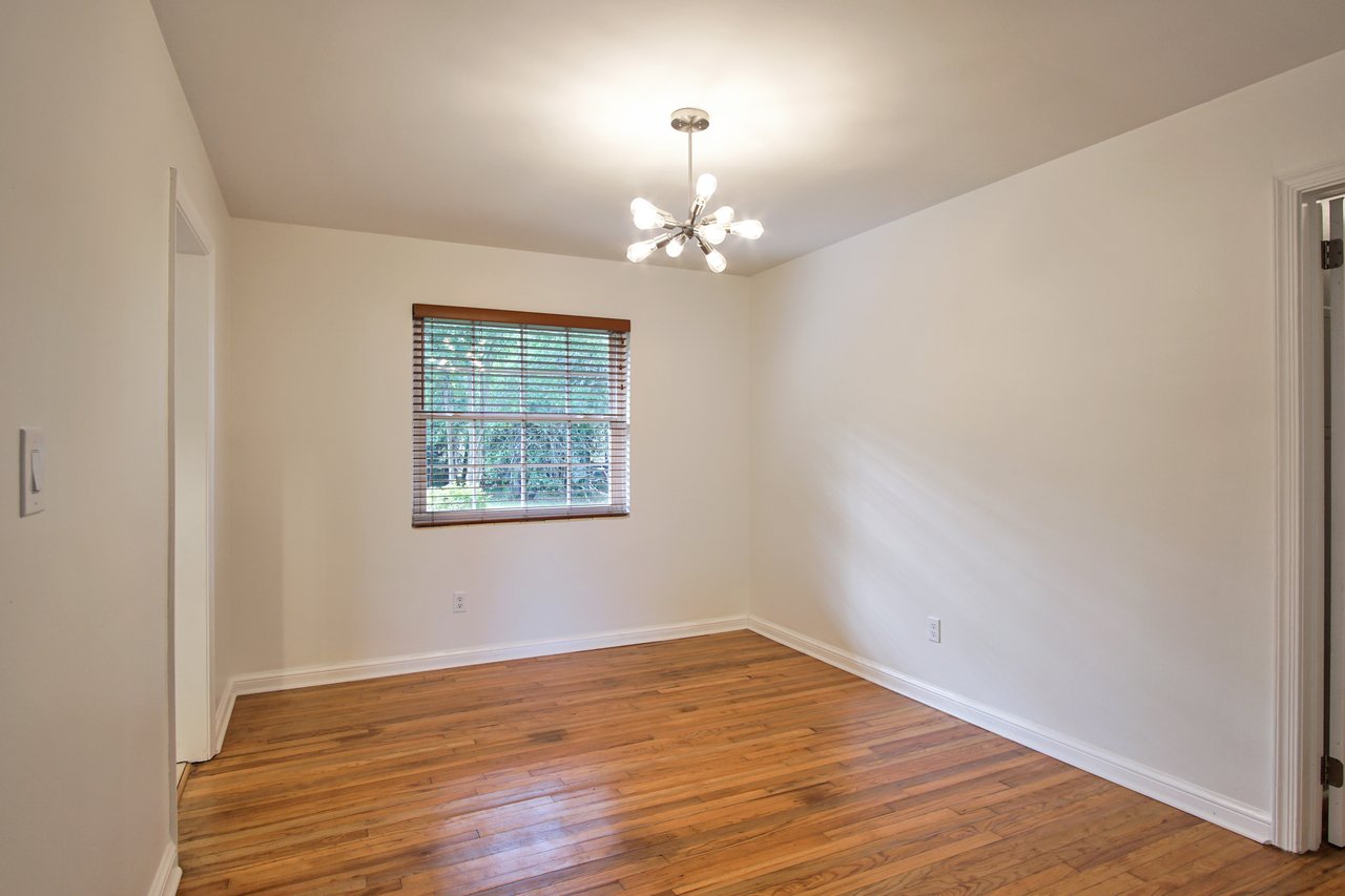 Empty room featuring hardwood floors and white walls, creating a bright and spacious atmosphere.