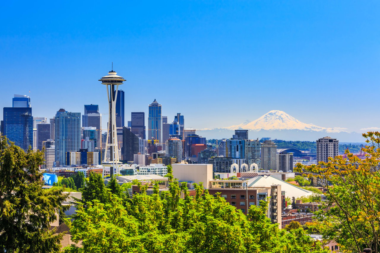 A view of a city skyline with a mountain in the background.