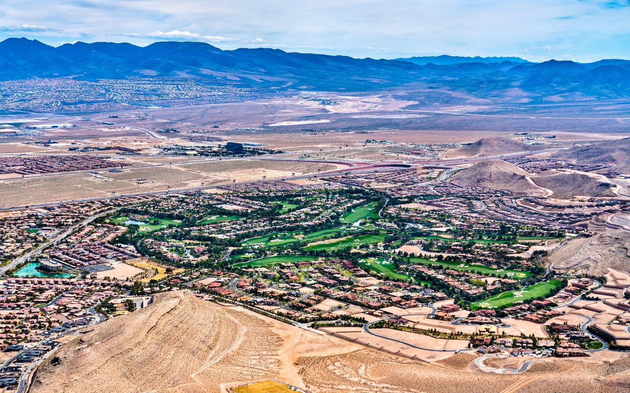Aerial view of Southern Highlands, with golf course fairways, desert terrain, and distant mountains.