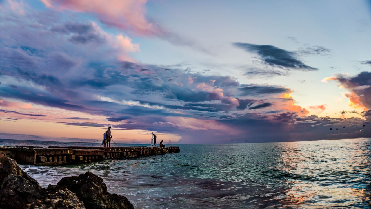 bird key sunset with people standing on the boat docks fishing