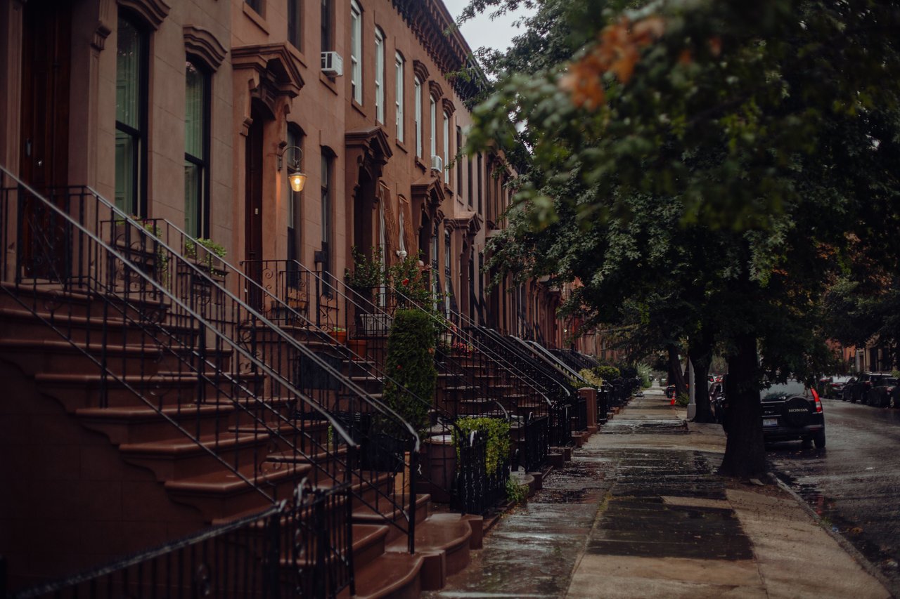 Historic brownstones, mixed-use buildings, boutique shops, restaurants, and tree-lined sidewalks along Court Street in Carroll Gardens, Brooklyn.