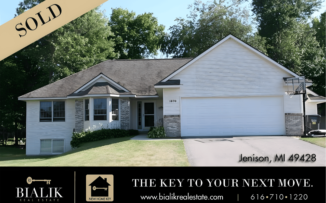 Sold white house in Jenison with a two-car garage, stone accents, and a basketball hoop by the driveway.