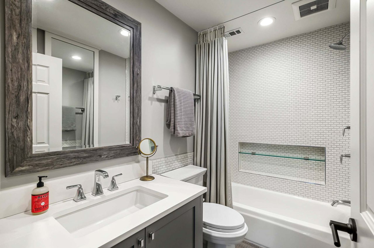 Bathroom with subway tile and wood-framed mirror at 1500 Northwood Rd, Pemberton Heights, Austin.