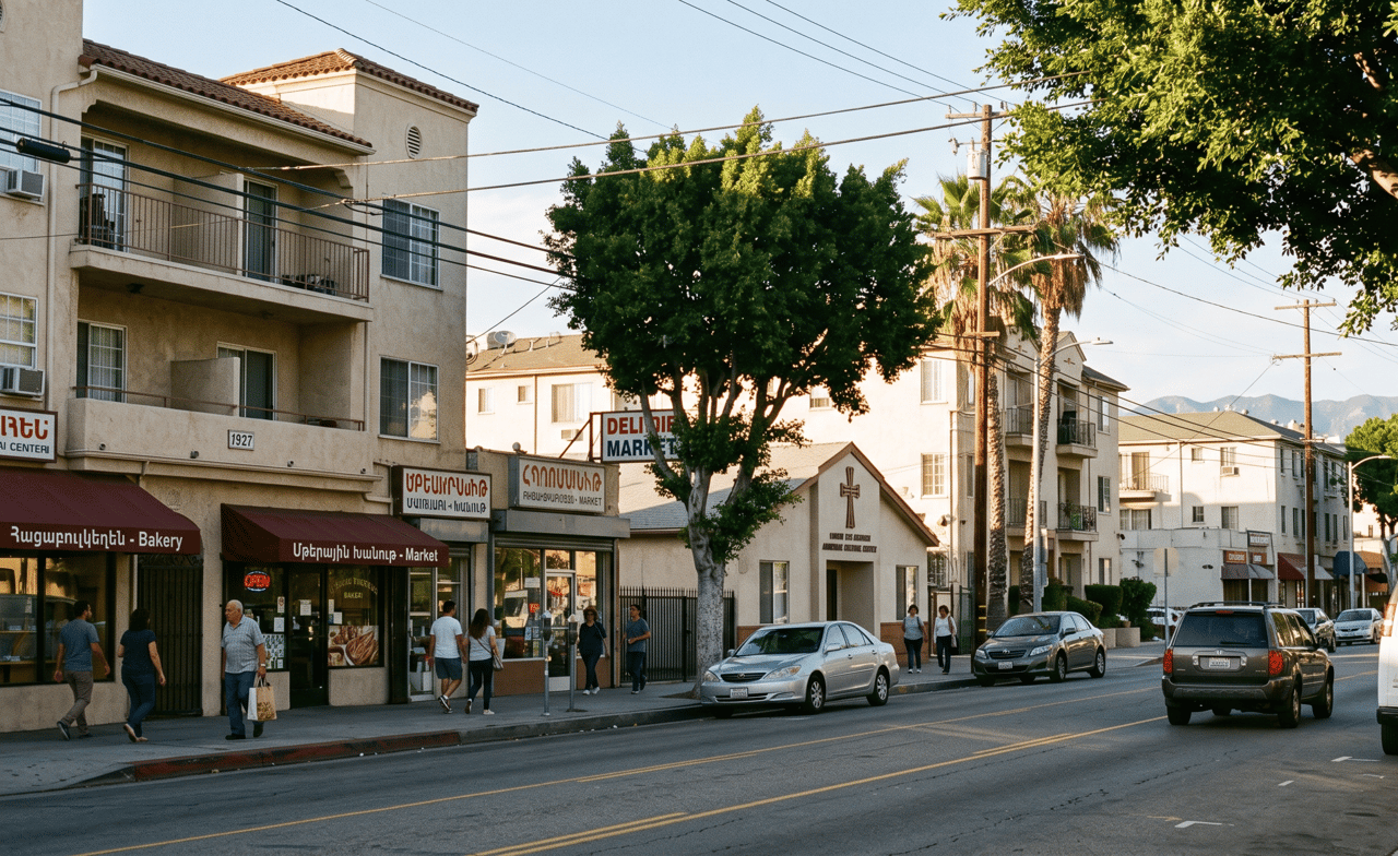 Neighborhood street with Armenian shops, apartment buildings, pedestrians, and mountains in the distance.