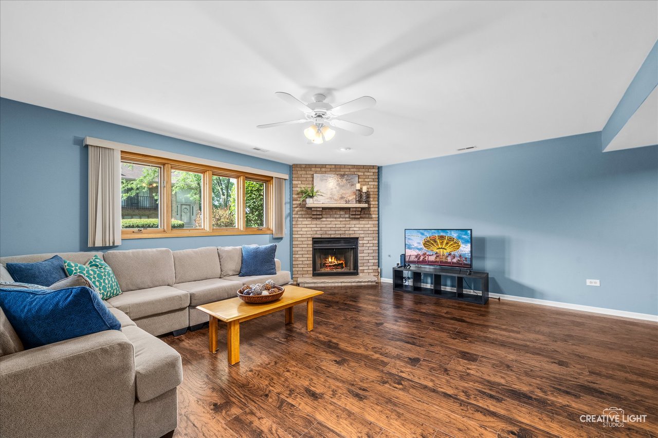 Lower level family room with new hardwood flooring and a full height masonry fireplace at 8316 Woodland Drive Darien IL