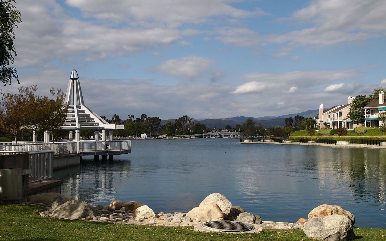 North Lake in Irvine's Woodbridge village, with lakefront homes and the Saddleback foothills beyond