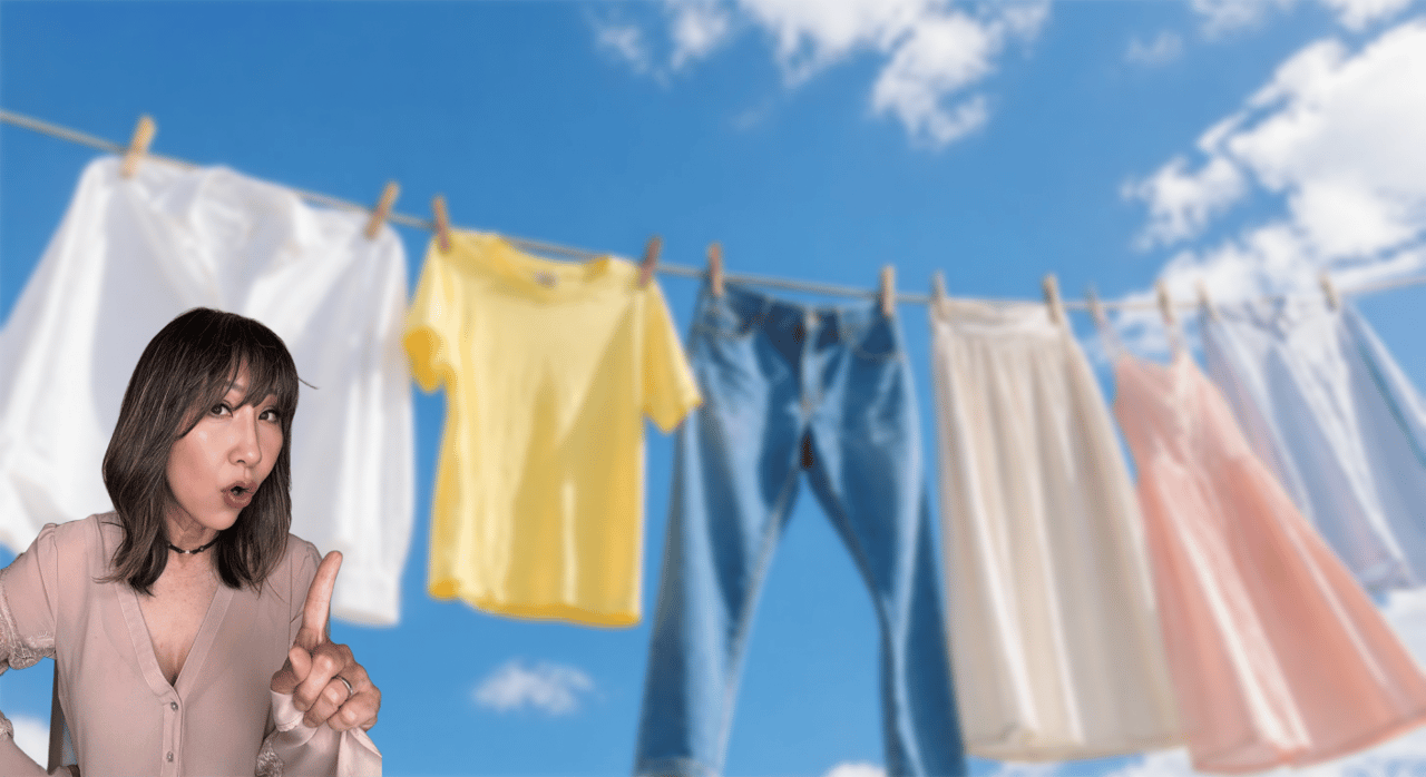 A woman gestures beside colorful laundry drying on a clothesline against a blue sky.