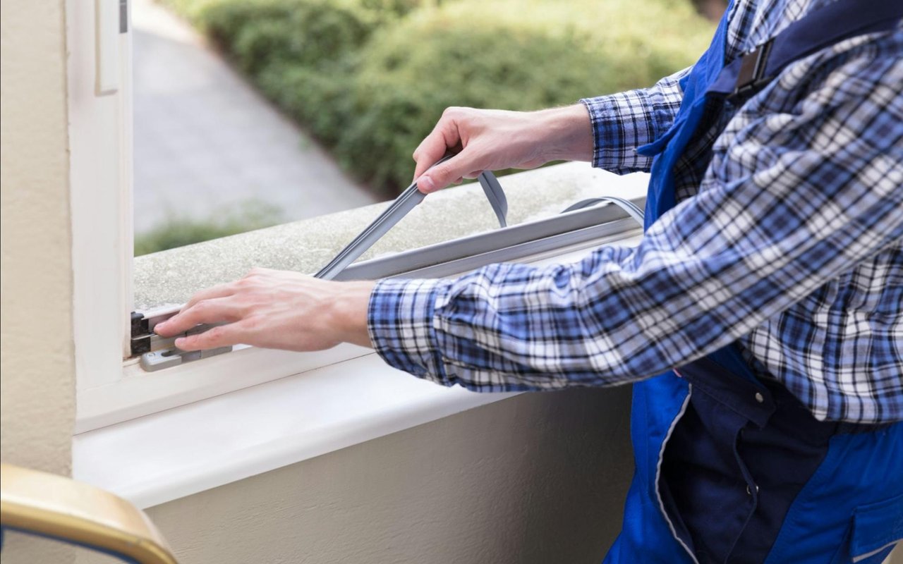 Worker adjusting the hardware on a white-framed window
