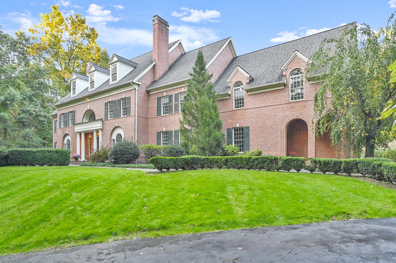 Elegant brick estate at 59 Lord Davis Lane in Avon, Connecticut, featuring stately columns and classic New England architecture.