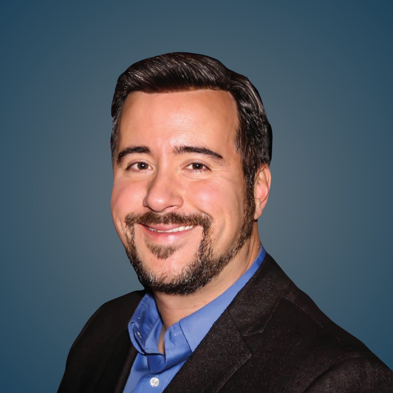 Hermon Barbe, smiling in a blue shirt and dark blazer.
