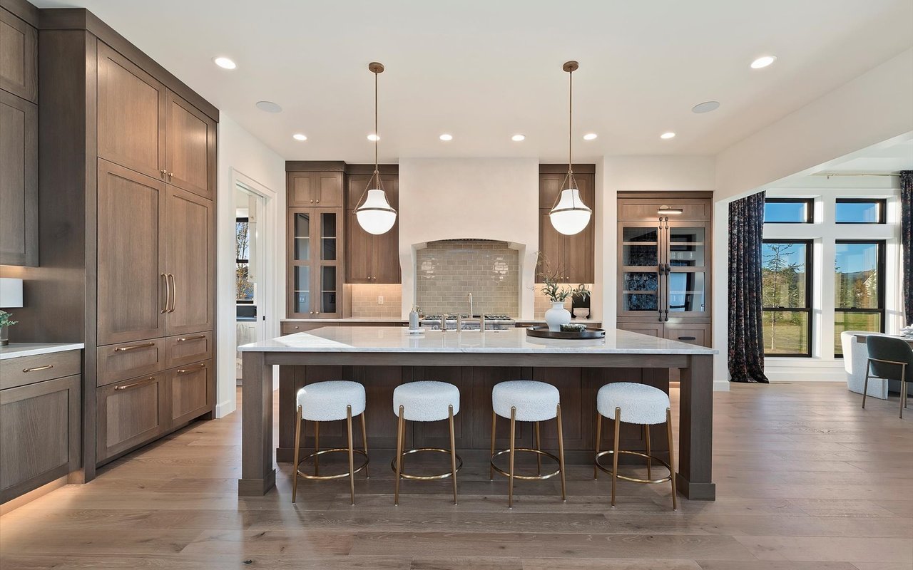 Kitchen featuring wide-plank oak floors, wood cabinets, and oversize island