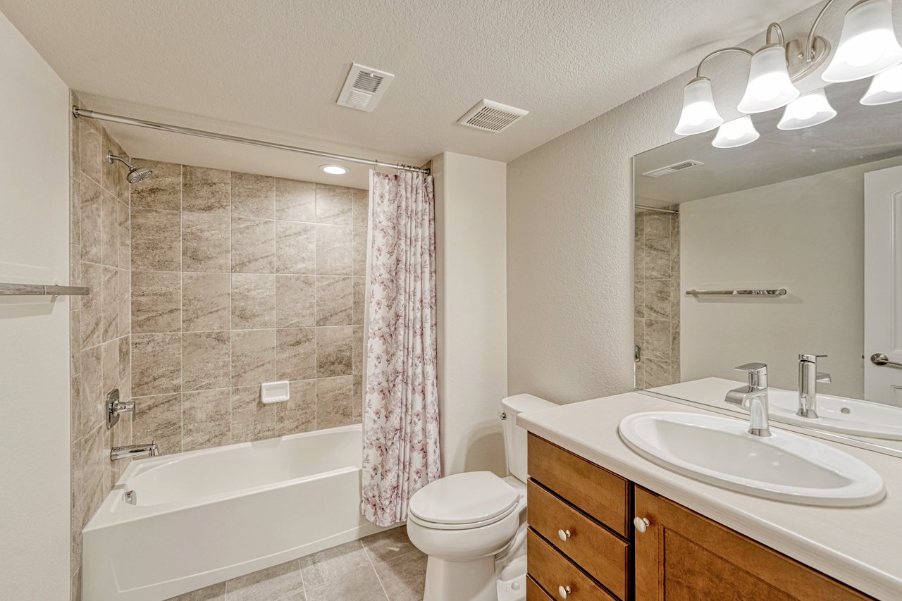 Lower-level full bathroom with tiled tub-shower