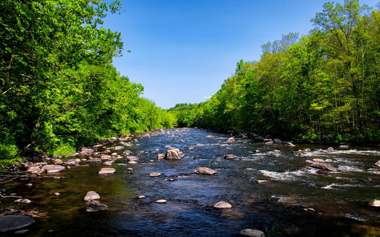 Historic Farmington, Connecticut, featuring colonial architecture, tree-lined streets, and views of the Farmington River and rolling hills.