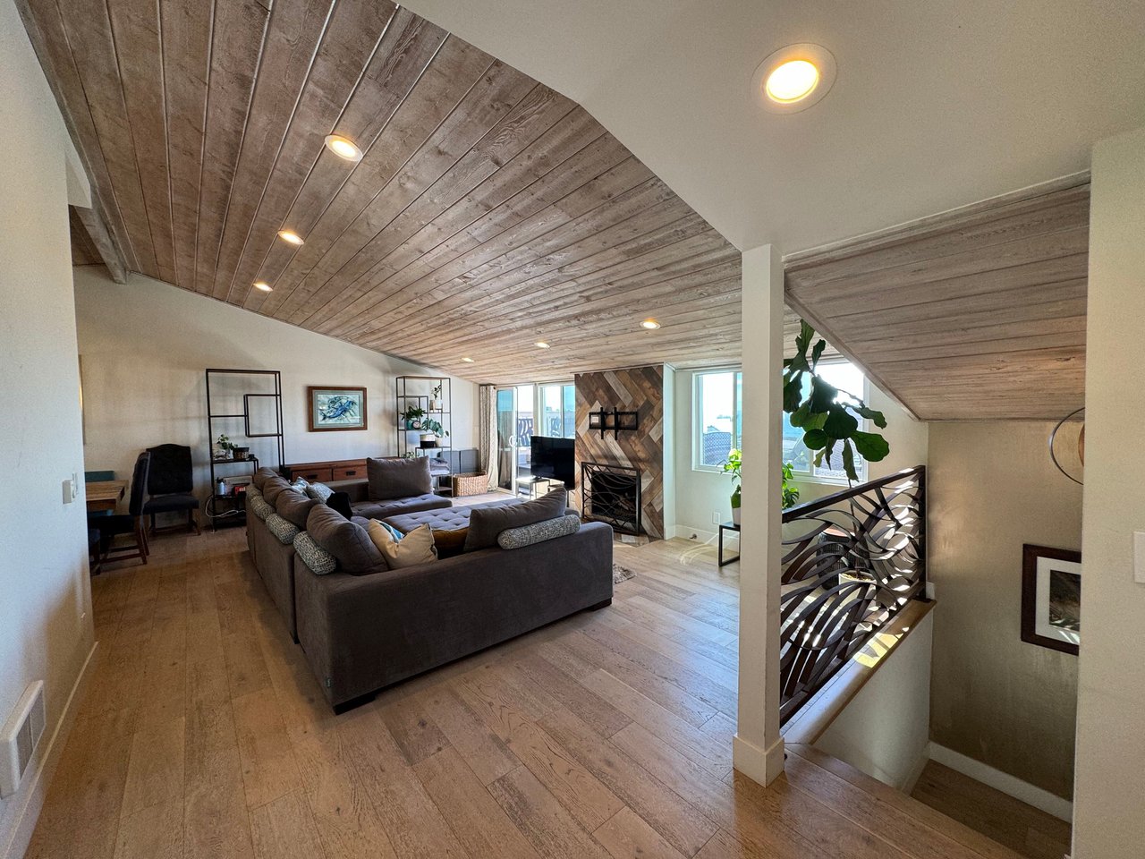 Spacious open living room with wood plank ceiling, modern railing, sectional sofa, and natural light at 533 S Sierra Ave, Solana Beach, CA 92075 oceanview rental.