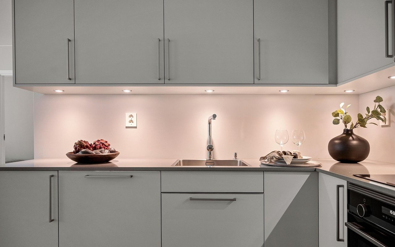 Modern gray kitchen with flat-front cabinets, a dark countertop, and a built-in oven.