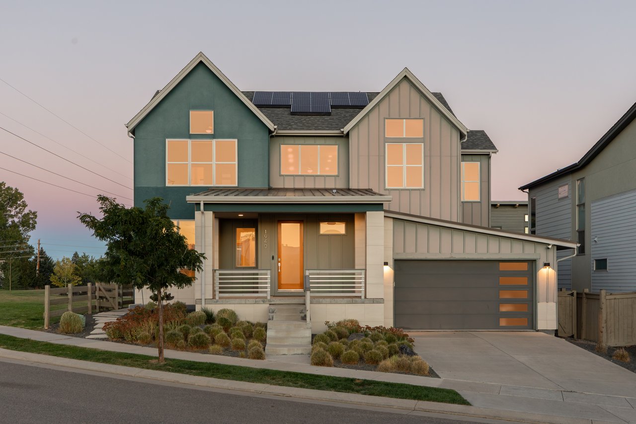 Front of the home at twilight with the garage and landscaped entry walk