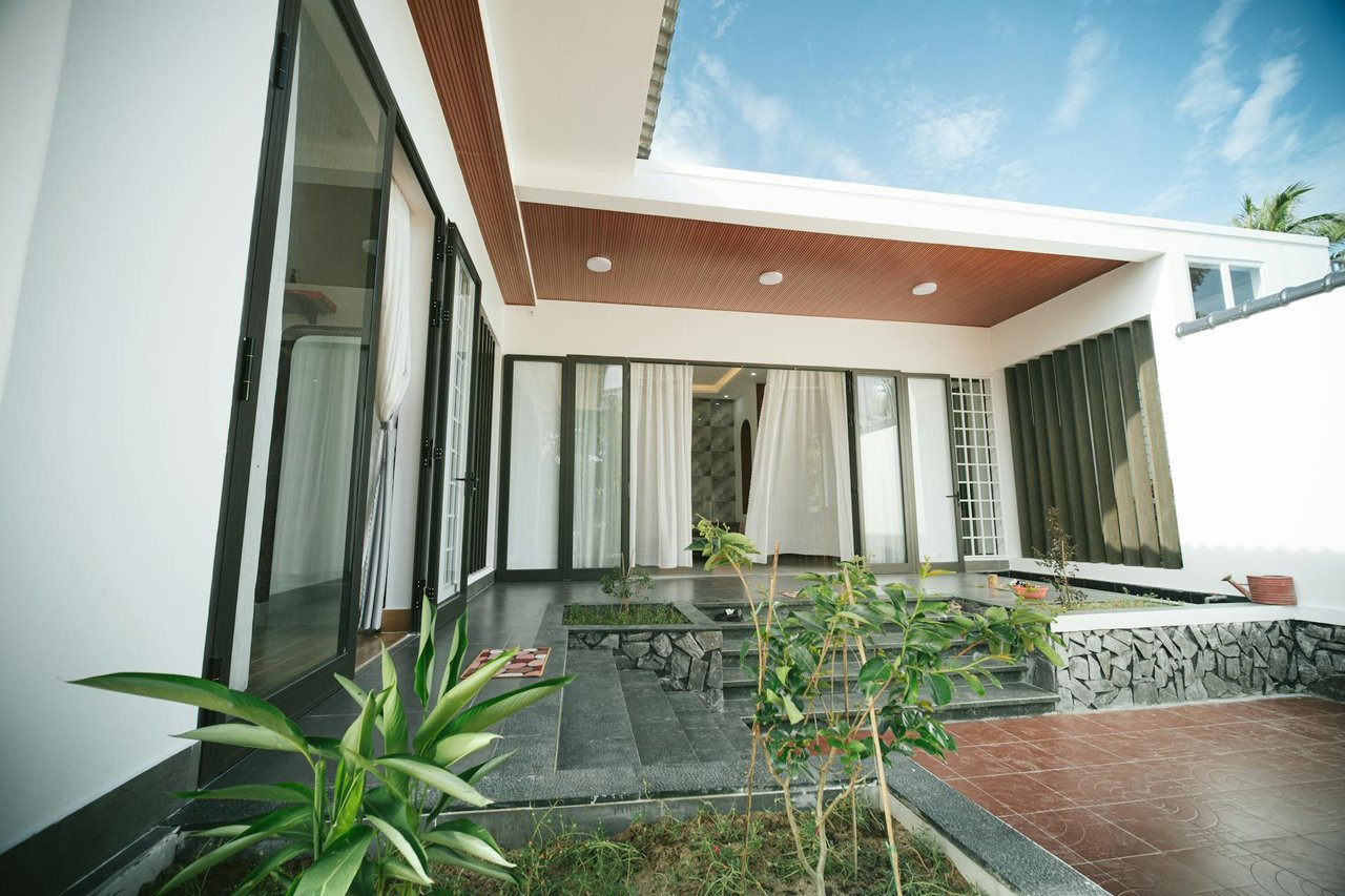 Modern luxury home patio with sliding glass doors, landscaped courtyard, and contemporary exterior design