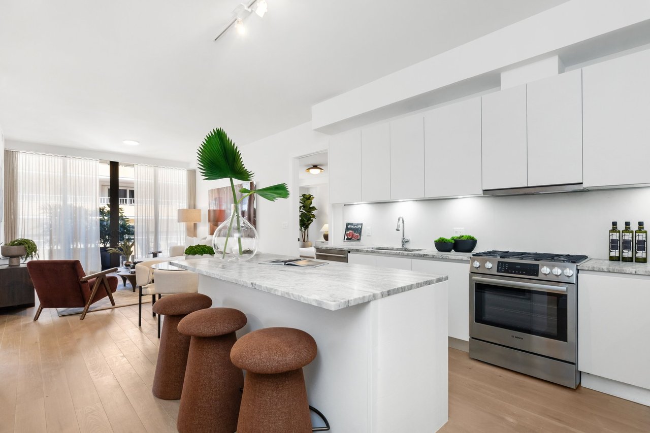 Arbor Coconut Grove residence kitchen with stone island and bar stools