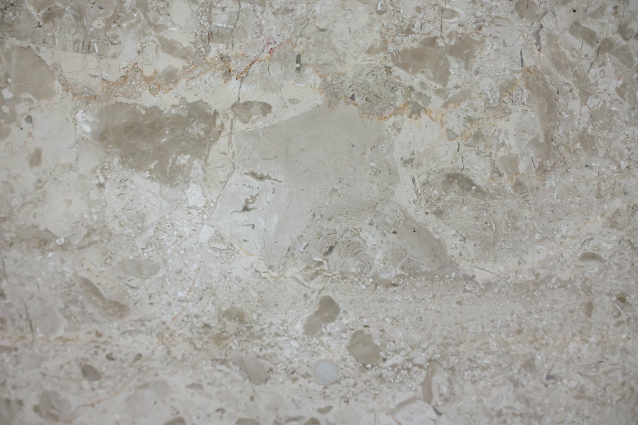 Beige stone surface with mottled mineral patterns and natural veining.