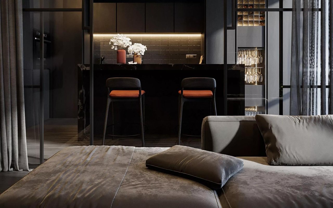 Living room facing a dark kitchen bar, with orange-cushioned stools and illuminated glassware cabinets.