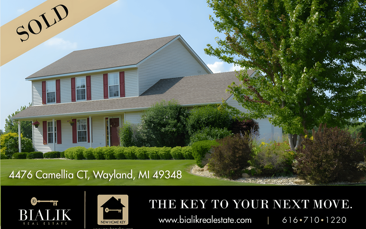Sold two-story house with red shutters and a landscaped front yard in Wayland, Michigan.