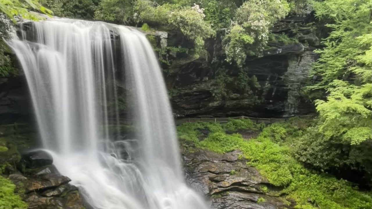 Dry Falls waterfall near Highlands NC, surrounded by lush green forest