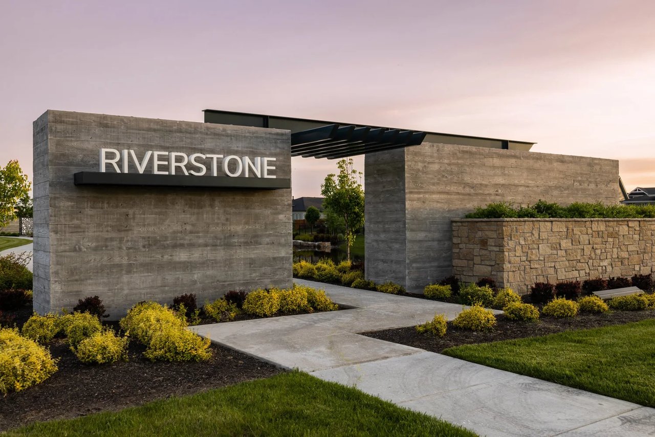 Riverstone neighborhood entrance with a concrete monument sign and landscaped walkway.