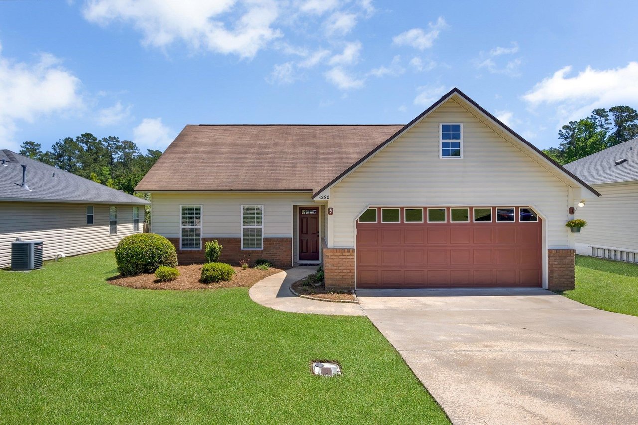 A residential home featuring a garage and a paved driveway, showcasing a welcoming exterior.