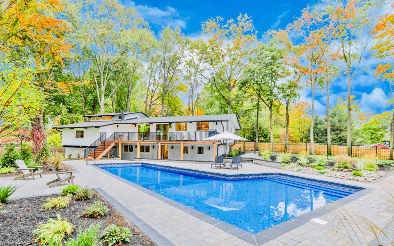 ```text norwood-nj luxury backyard with pristine swimming pool and modern home exterior 