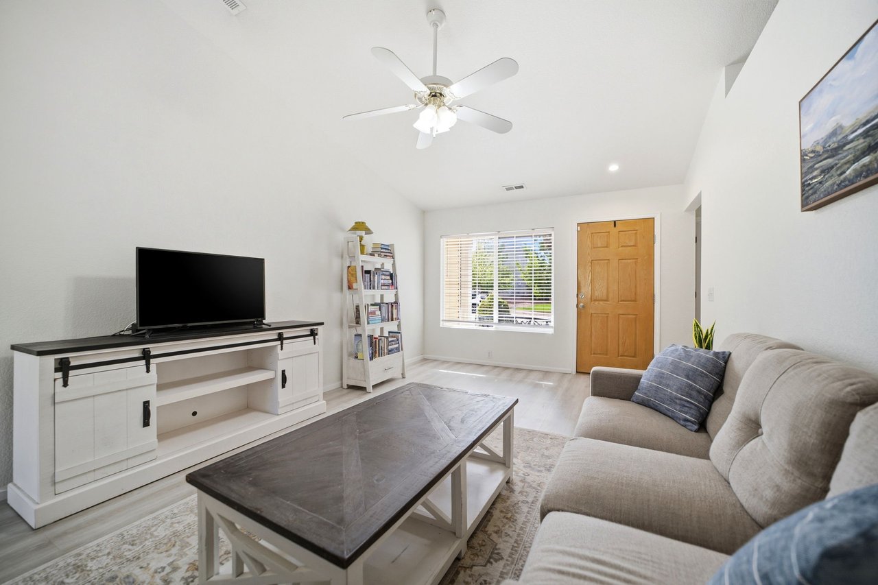 Living room with vaulted ceilings leading to front entry door