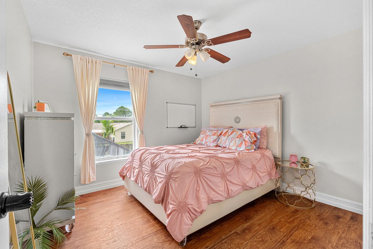 Upstairs bedroom with natural light and wood-look flooring