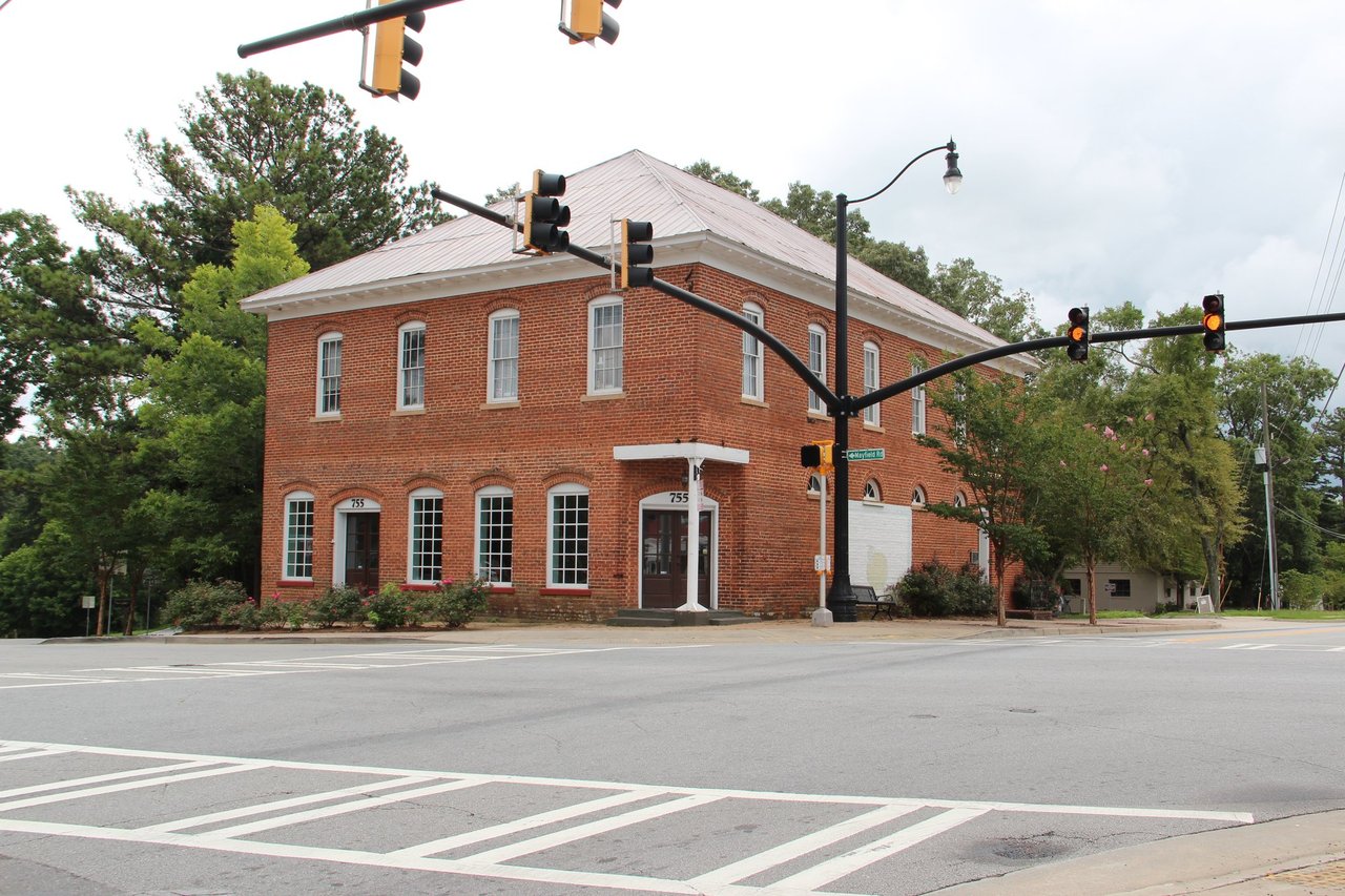 Two-story red brick building at a signalized intersection in Crabapple, Milton, Georgia