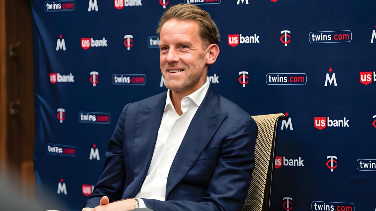 Tom Pohlad seated in a navy suit before a Minnesota Twins press backdrop.