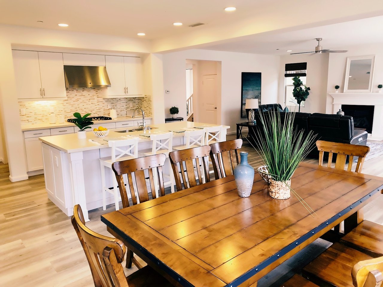 Bright, open-concept Carmel Valley-San Diego-92130 home featuring a modern kitchen with white cabinetry, large island, and stainless steel appliances—flowing into a stylish dining area and cozy living room, curated by FW Property Group for lifestyle-driven real estate