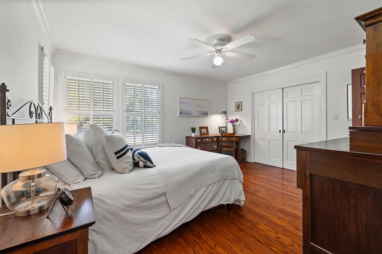 Bedroom with original wood floors and an iron bed frame, Tarrytown, Austin.