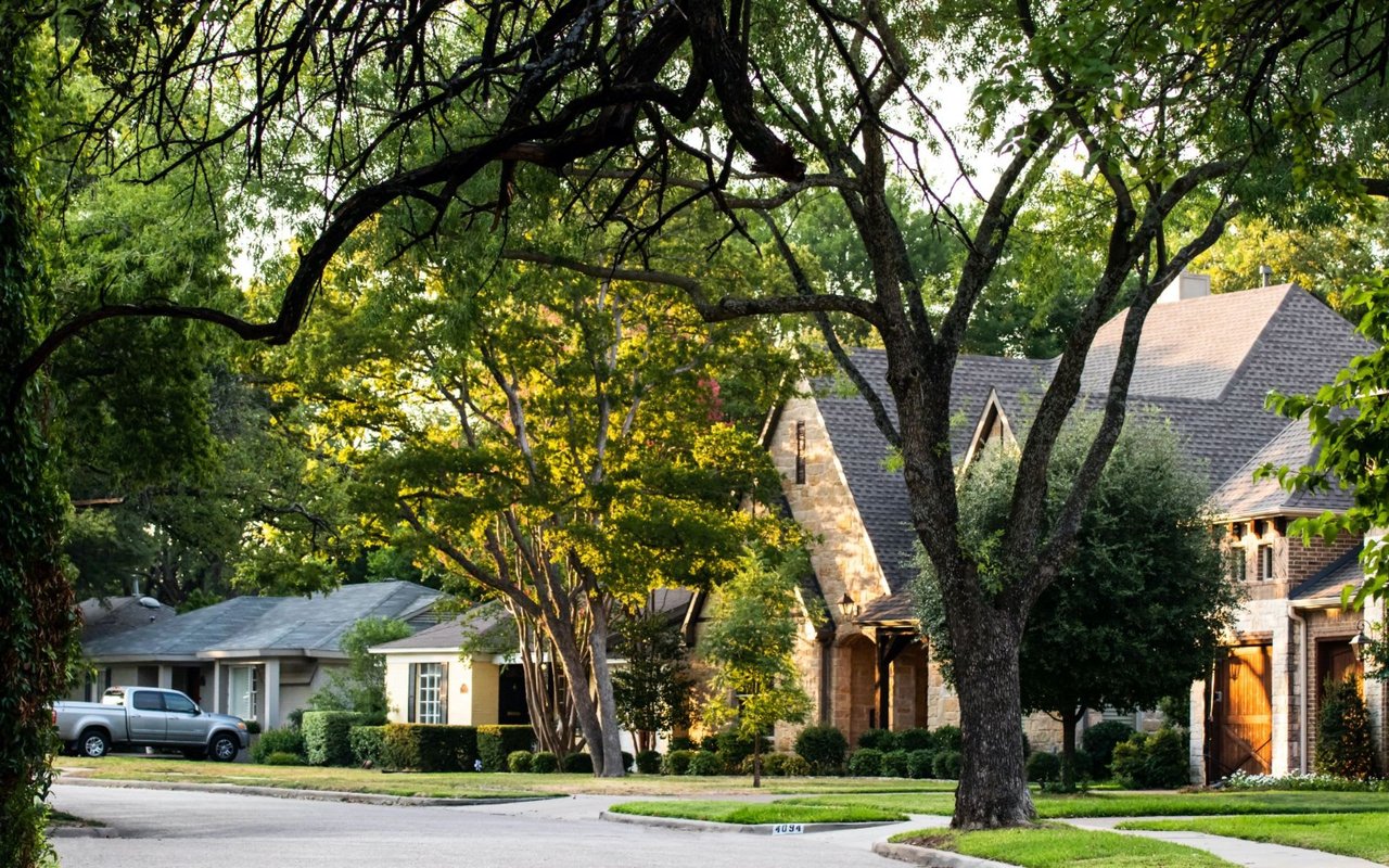 Neighborhood street with multiple houses in Benbrook Texas and cars in their driveways