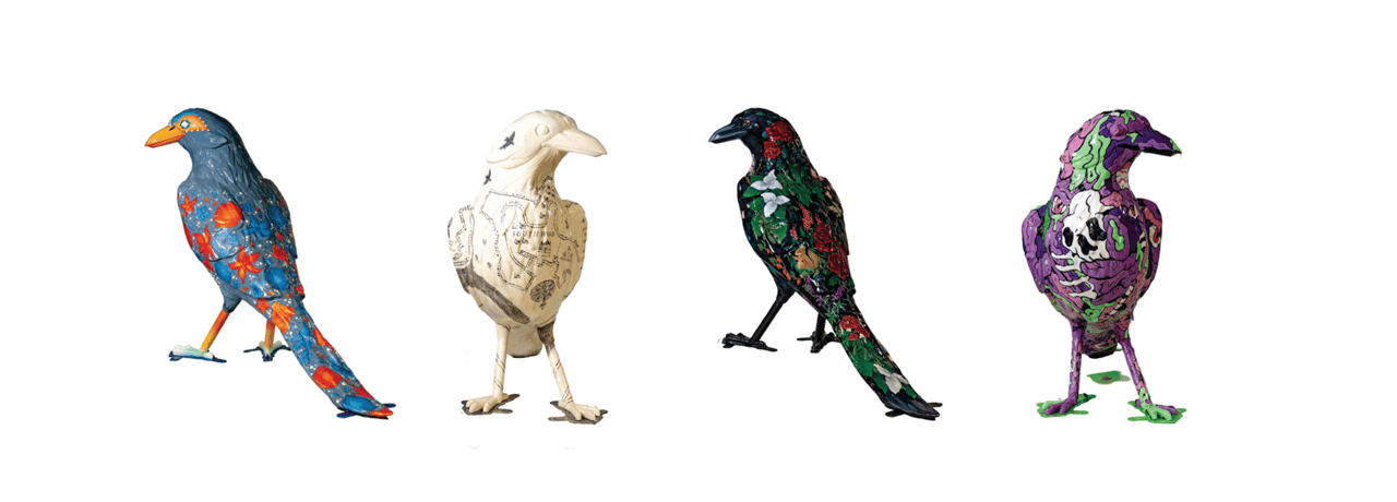 Four painted bird sculptures in blue, cream, black, and purple with distinct patterns.