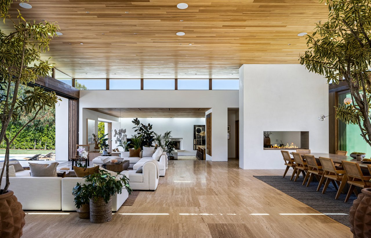 Contemporary great room with a wood-plank ceiling, white sofas, linear fireplace, and dining area.