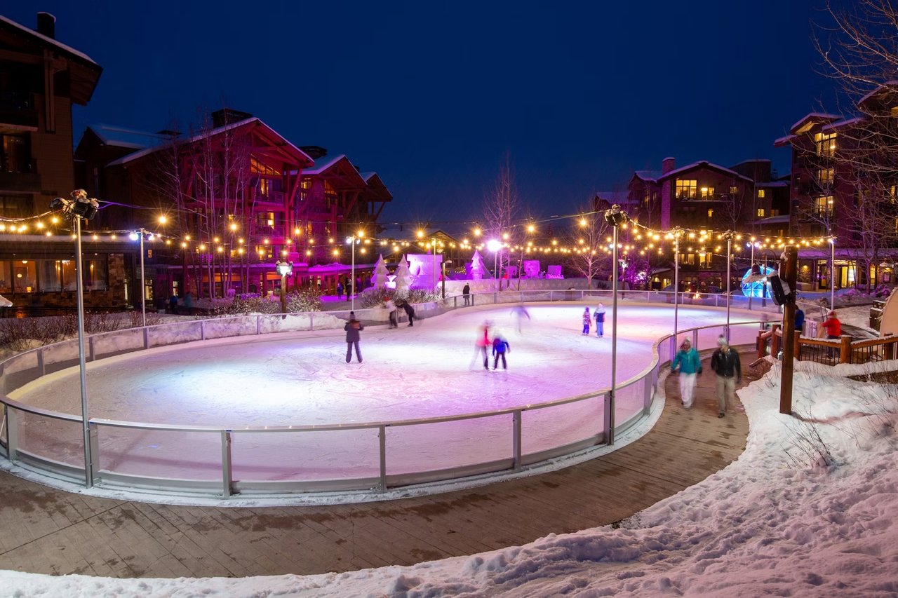 Downtown Jackson Hole decorated with holiday lights in November, with snow-covered mountains in the background, showcasing the vibrant community atmosphere and winter charm.