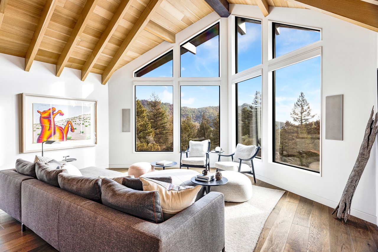 Contemporary Boulder living room with gray sectional, geometric art, and panoramic mountain views through floor-to-ceiling windows