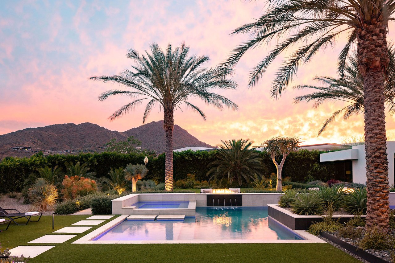 Modern luxury home in Paradise Valley with resort-style backyard, pool, fire feature, and contemporary architecture at sunset.