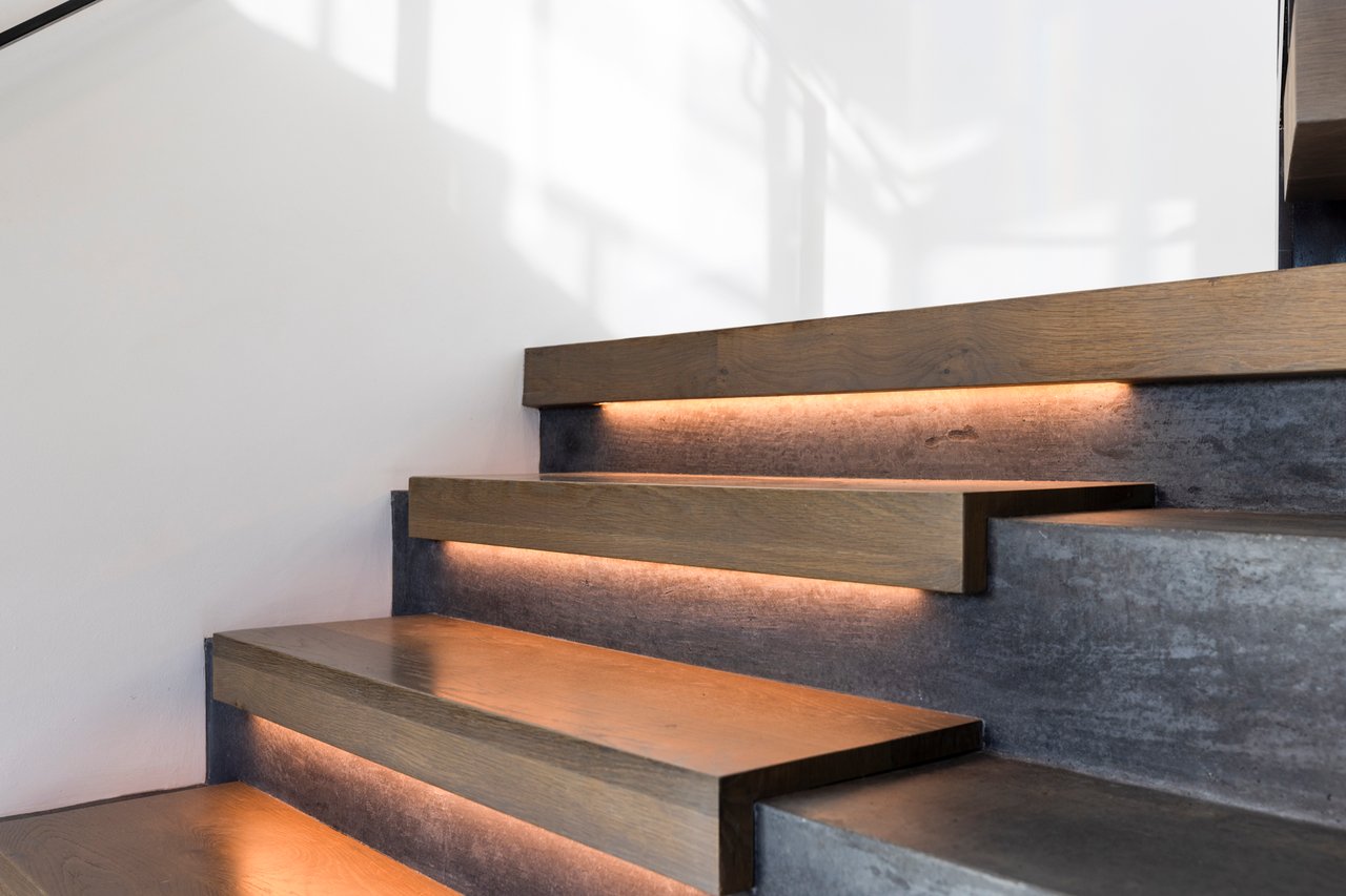 Architectural staircase in Boulder home featuring wood treads with LED underlighting and concrete risers