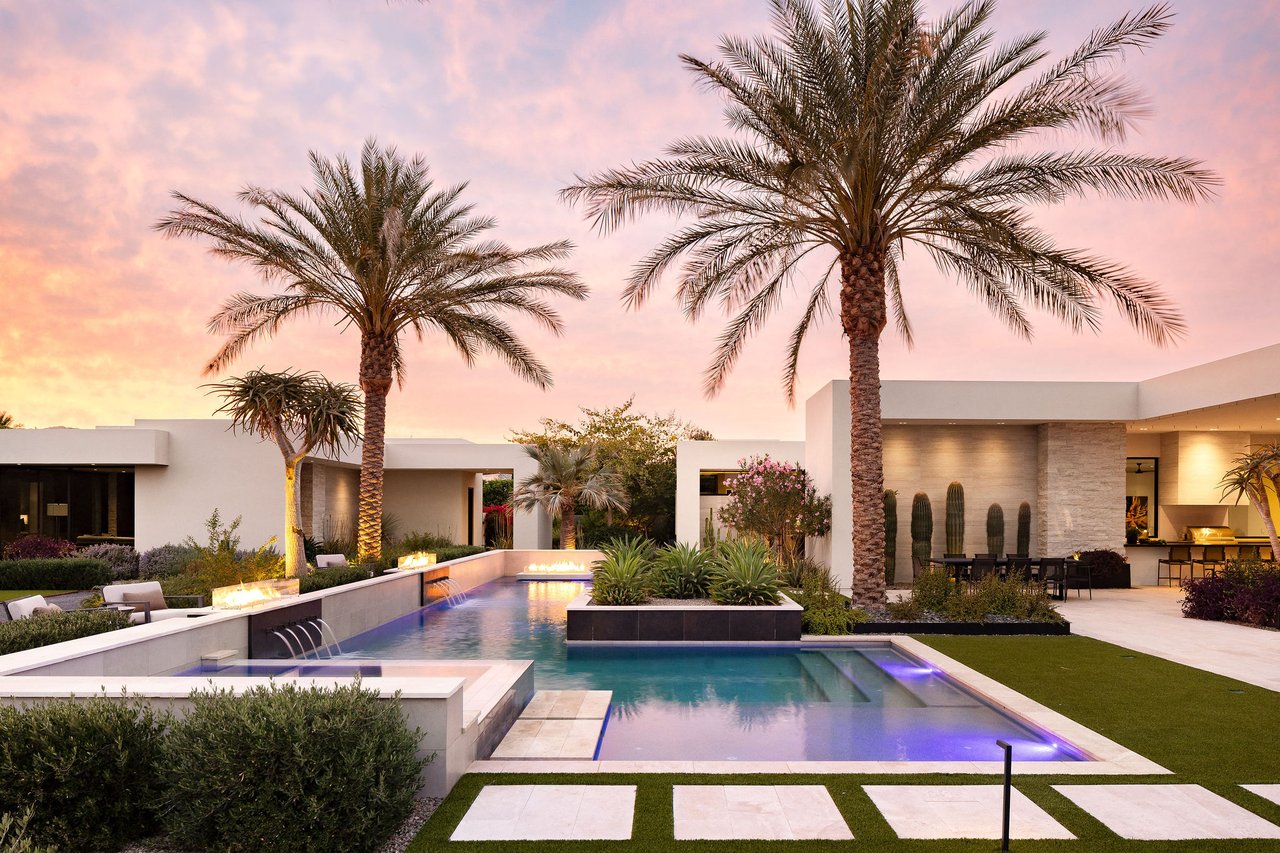 Modern luxury home in Paradise Valley with resort-style backyard, pool, fire feature, and contemporary architecture at sunset.