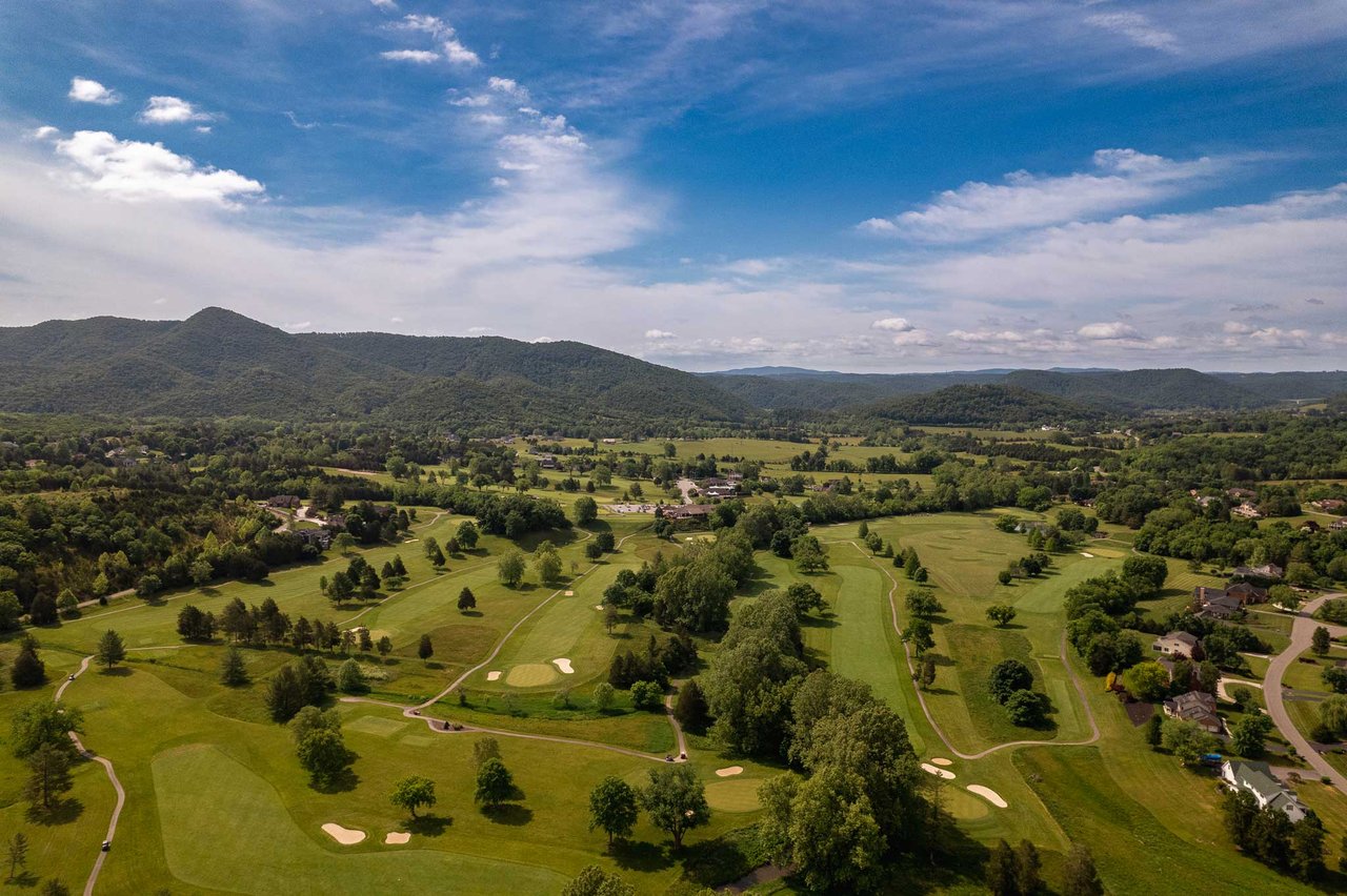 aerial view of golfcourse with mountain skyline