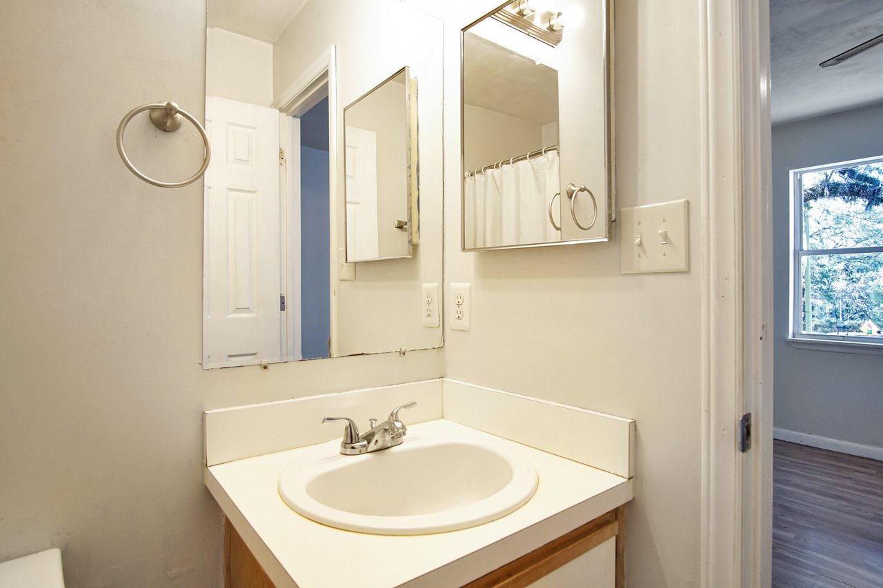 A clean bathroom featuring a modern sink and a large mirror reflecting the space.