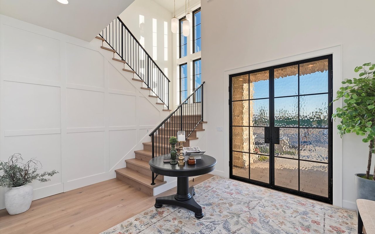 Inside the front entry - glass and black steel double doors and staircase